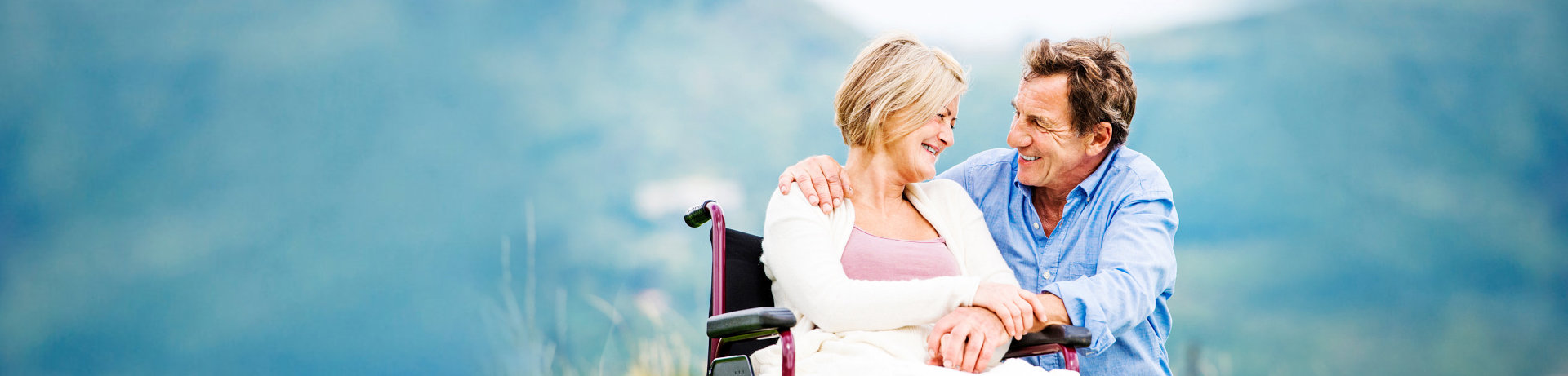 woman on a wheelchair smiling at her husband