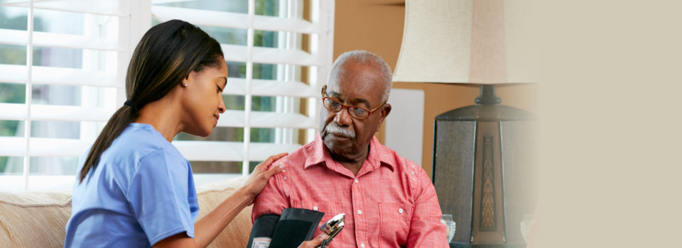caregiver checking the health of an elderly man