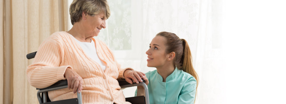 elderly woman on a wheelchair and her caregiver