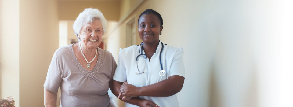 caring female nurse assisting a senior patient to walk.